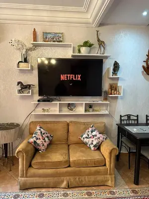 a living room with a couch and a flat screen tv at Appartement Marrakech Gueliz in Marrakech