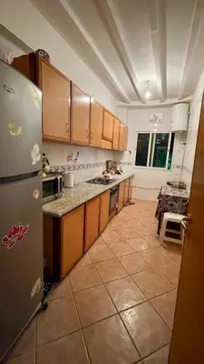 a kitchen with a refrigerator and a tile floor at Appartement Marrakech Gueliz in Marrakech