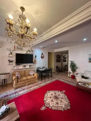 a large living room with a red rug and a chandelier at Appartement Marrakech Gueliz in Marrakech