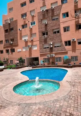 a fountain in a courtyard in front of a building at Appartement Marrakech Gueliz in Marrakech