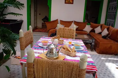 a table with food and drinks on it in a living room at Riad ELJazouli in Marrakech