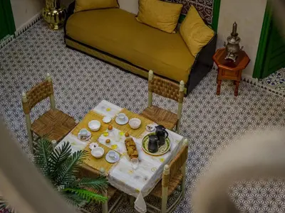 a living room with a table and a couch at Riad ELJazouli in Marrakech