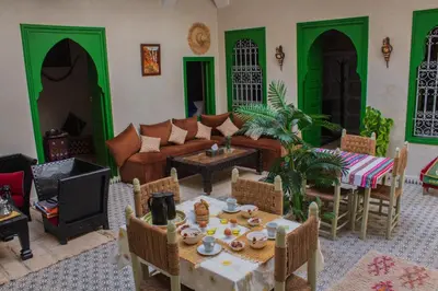 a living room with a couch and a table at Riad ELJazouli in Marrakech