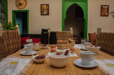 a table with cups and bowls of food on it at Riad ELJazouli in Marrakech