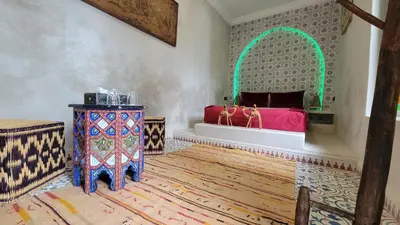 a room with a bed and a table in a room at Riad ELJazouli in Marrakech