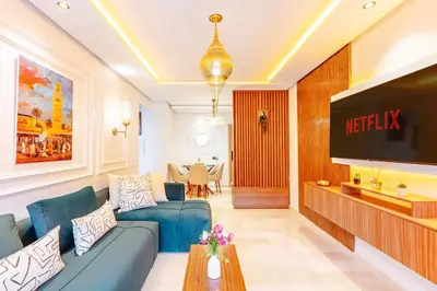 a living room with a blue couch and a tv at Guéliz I Blue Mirage I Crafts and modernity in Marrakech