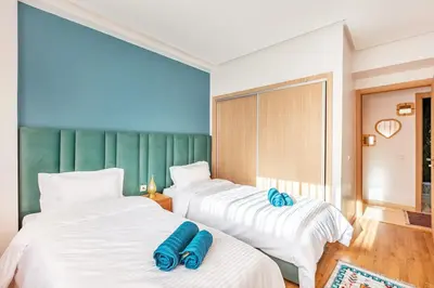 two beds in a room with blue pillows on them at Guéliz I Blue Mirage I Crafts and modernity in Marrakech