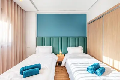 two beds in a room with blue pillows on them at Guéliz I Blue Mirage I Crafts and modernity in Marrakech