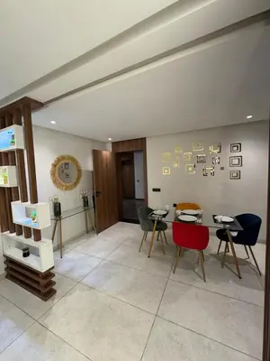 a living room with chairs and a table and a clock at Stylish 2-Bed Retreat in Marrakech Free Parking in Marrakech