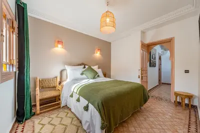 a bedroom with a bed and a chair at Villa Chahrazad - 8prs - Piscine - Wifi in Marrakech