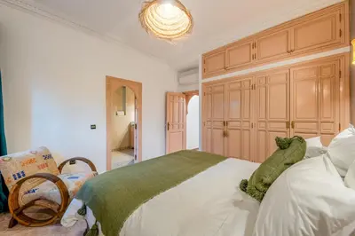 a bedroom with a large bed and a chandelier at Villa Chahrazad - 8prs - Piscine - Wifi in Marrakech