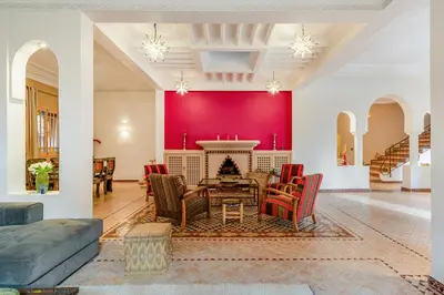 a living room with a fireplace and red walls at Villa Chahrazad - 8prs - Piscine - Wifi in Marrakech