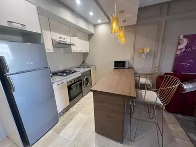 a kitchen with a refrigerator and a table and chairs at Modern apartment with pool view, Kech in Marrakech