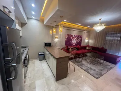 a kitchen and living room with a couch and a table at Modern apartment with pool view, Kech in Marrakech