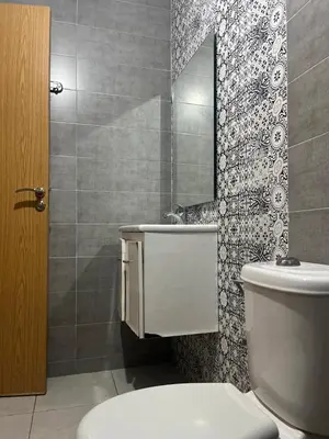 a bathroom with a toilet and a sink and a mirror at appartement 2 chabres marrakech in Marrakech
