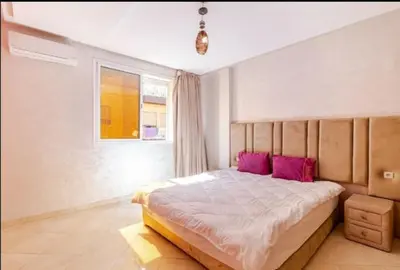 a bedroom with a large bed with purple pillows at appartement 2 chabres marrakech in Marrakech