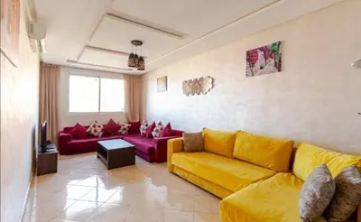 a living room with a yellow couch and red couches at appartement 2 chabres marrakech in Marrakech