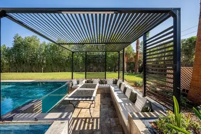 a swimming pool with a pergola next to a house at Palais Mahora in Marrakech