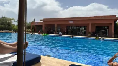 a large swimming pool in front of a building at Appartement Ksour in Sraghna