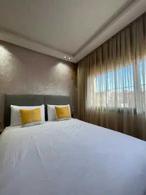 a bedroom with a large white bed with yellow pillows at MayyRakech in Marrakech