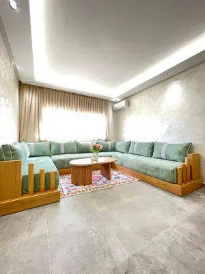 a living room with a green couch and a table at MayyRakech in Marrakech