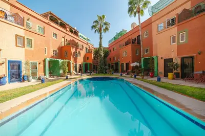 a swimming pool in the courtyard of a building at Riad Marrakech Red Ruby in Marrakech