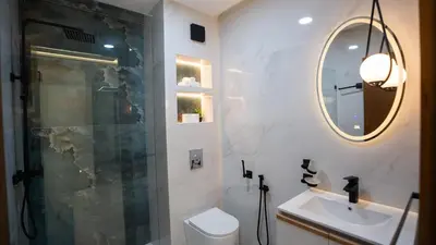 a bathroom with a shower and a sink and a mirror at Appartement Moderne à Guéliz in Marrakech