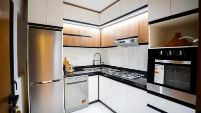 a kitchen with white cabinets and stainless steel appliances at Appartement Moderne à Guéliz in Marrakech