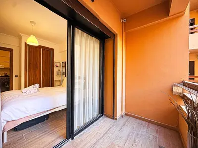 a bedroom with a bed and a sliding glass door at Le Nid de l'Hivernage - Piscine et Confort Moderne in Marrakech