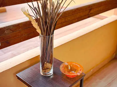 a vase with grasses in it sitting on a table at Le Nid de l'Hivernage - Piscine et Confort Moderne in Marrakech