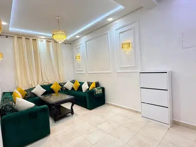 a living room with a green couch and a table at Appartement Cosy and Calme Proche Centre Marrakech in Marrakech