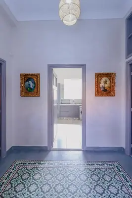 a white room with a door and a rug on the floor at Maison du Pacha in Marrakech
