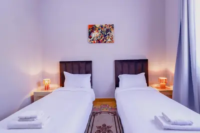 two beds in a room with two tables and two lamps at Maison du Pacha in Marrakech