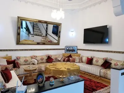 a living room with a couch and a tv at Riad Alhana in Marrakech