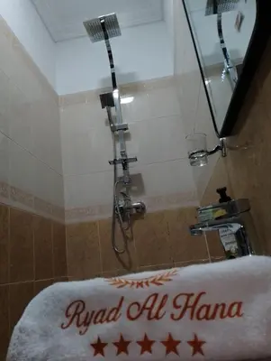 a bath tub with a shower with a sign on it at Riad Alhana in Marrakech