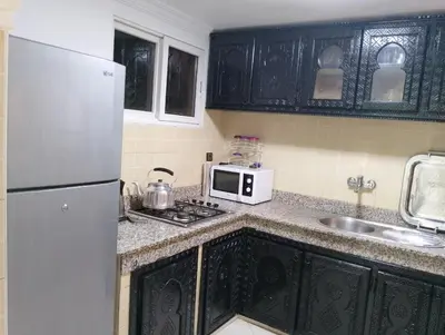 a kitchen with a white refrigerator and a sink at Riad Alhana in Marrakech