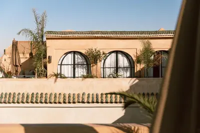 a building with three windows and a fence at Riad K in Marrakech
