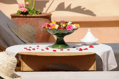 a green vase with flowers on a table at Riad K in Marrakech