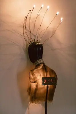a vase with twigs in it with a light at Riad K in Marrakech
