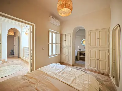 a bedroom with a large bed and a bathroom at Riad Medina Luxury Charm in Marrakech