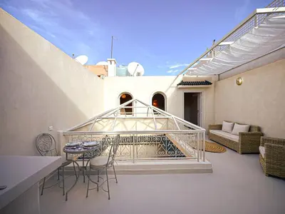a balcony with a table and chairs on a building at Riad Medina Luxury Charm in Marrakech