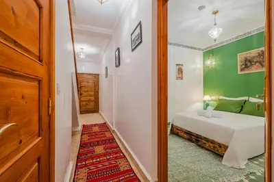 a bedroom with a bed and a green wall at Riad ZEROUAL in Marrakech