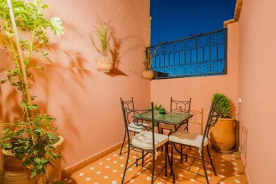 a table and chairs in a room with plants at Riad ZEROUAL in Marrakech