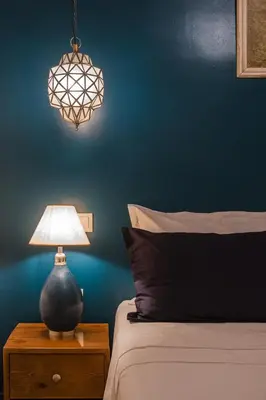 a lamp on a night stand next to a bed at Riad ZEROUAL in Marrakech
