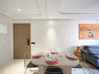 a living room with a table with chairs and a couch at Le Pavillon Gueliz Appart Chic Confort et Piscine in Marrakech