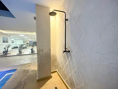 aanding shower in a gym with a wall at Le Pavillon Gueliz Appart Chic Confort et Piscine in Marrakech