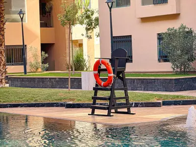 a life preserver is sitting next to a swimming pool at Le Pavillon Gueliz Appart Chic Confort et Piscine in Marrakech