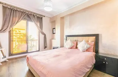 a bedroom with a large bed with a large window at Un super jolie appartement à gueliz in Marrakech