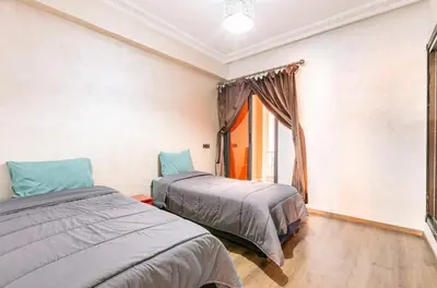 two beds in a room with a window at Un super jolie appartement à gueliz in Marrakech