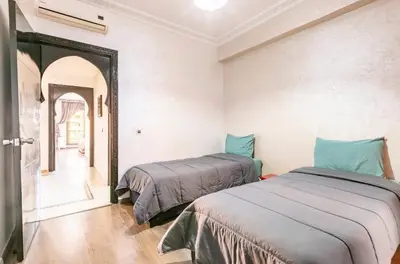 two beds in a room with a mirror at Un super jolie appartement à gueliz in Marrakech